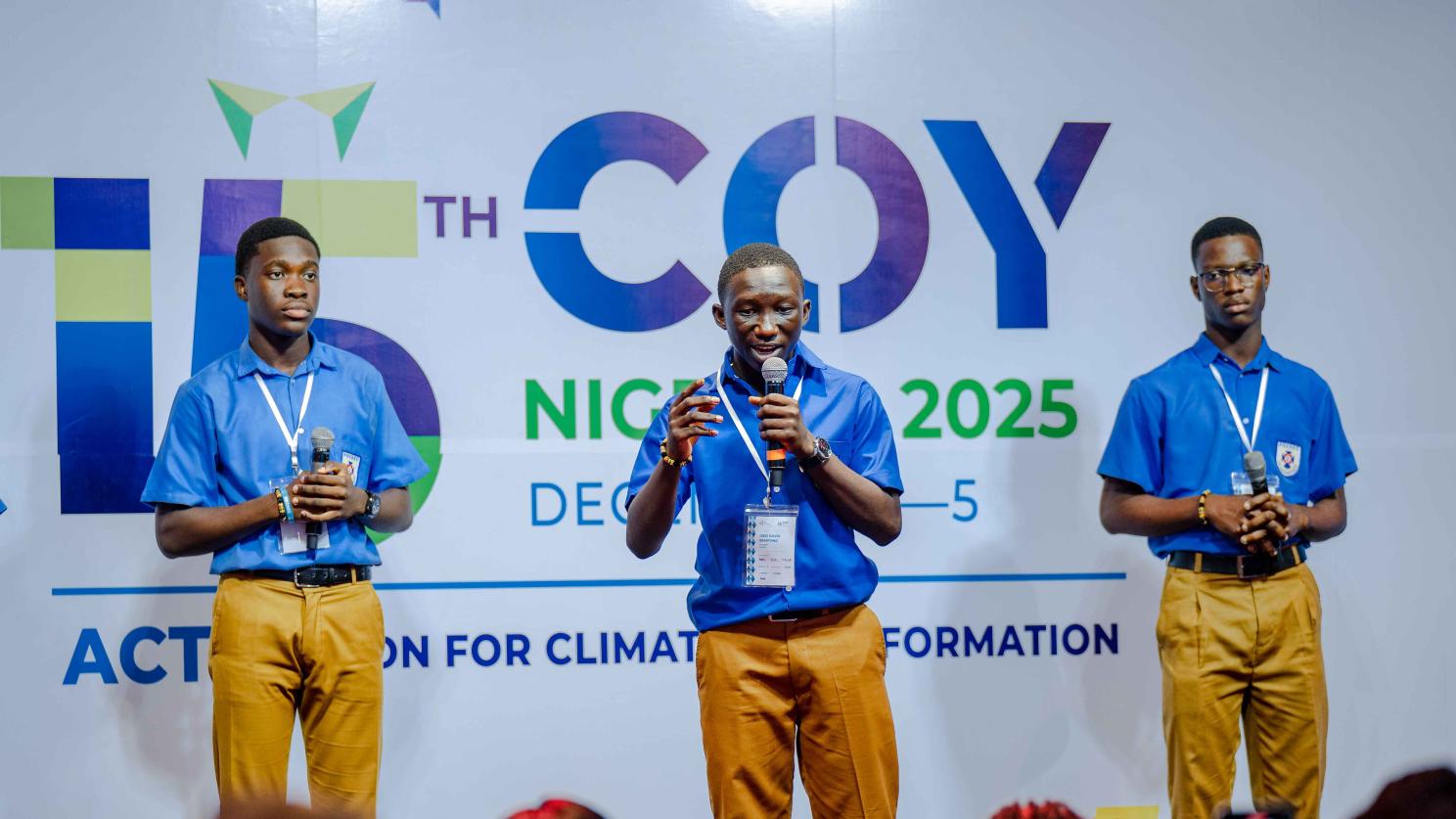 Three people holding microphones at COY 2025 event