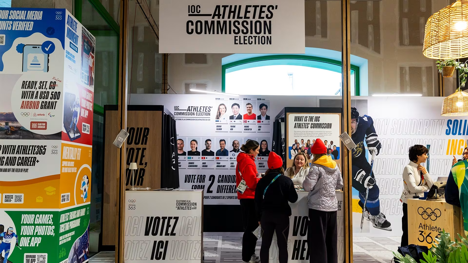 People gathered under sign reading, "IOC Athletes' Commission Election"