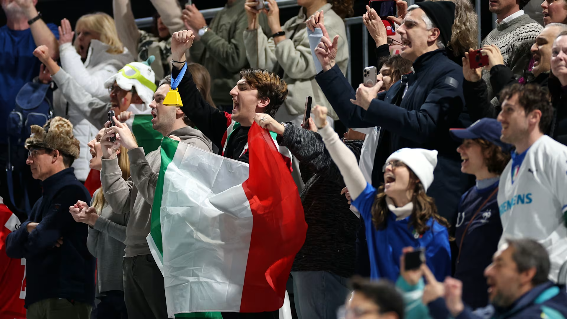 crowd cheering and holding up flags