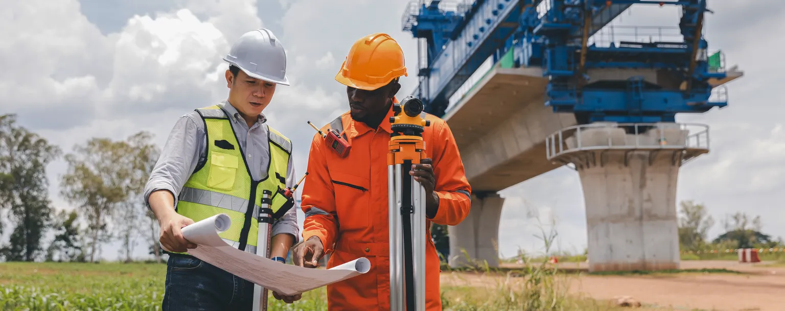 Two people looking at plans on construction site.