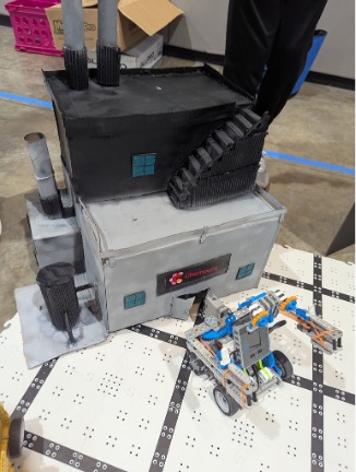 A robot that mimicks the process by scooping simulated dirt, transporting it, and depositing it into a miniature dump truck.