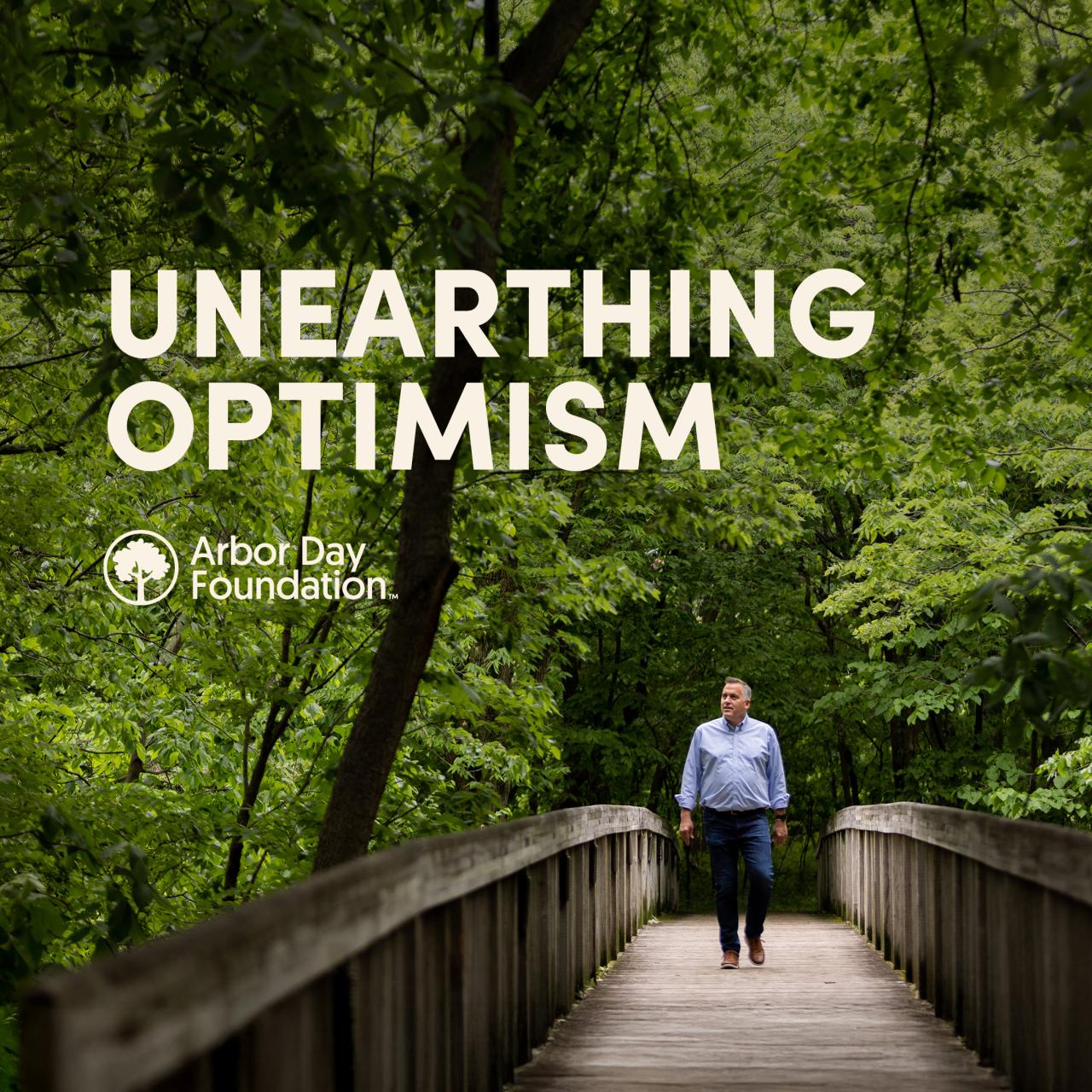 Unearthing Optimism podcast artwork features Arbor Day Foundation CEO walking down a bridge among trees. 