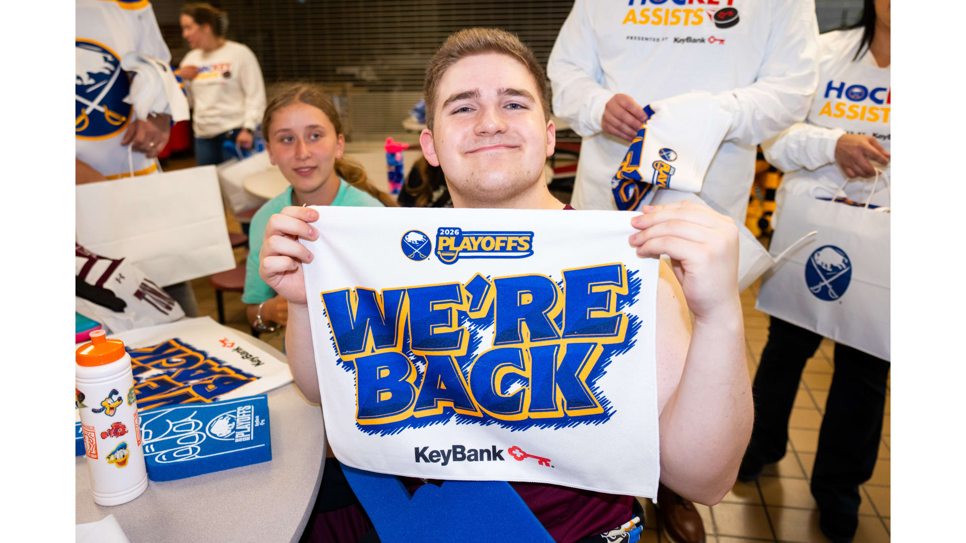 Someone holding up a "we're back" banner