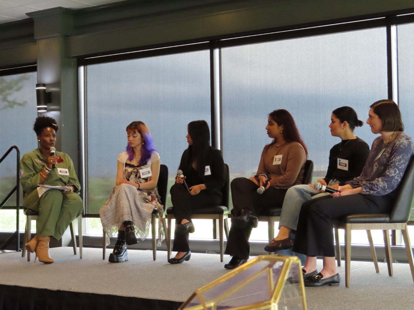 Six speakers seated on a stage