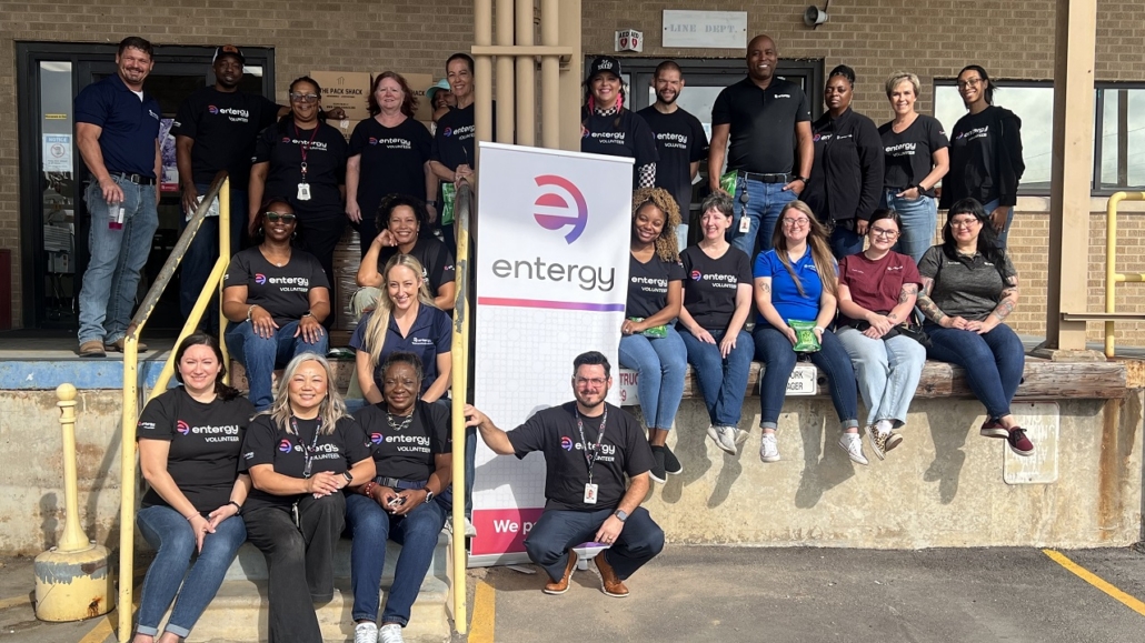 A group of volunteers by an Entergy sign