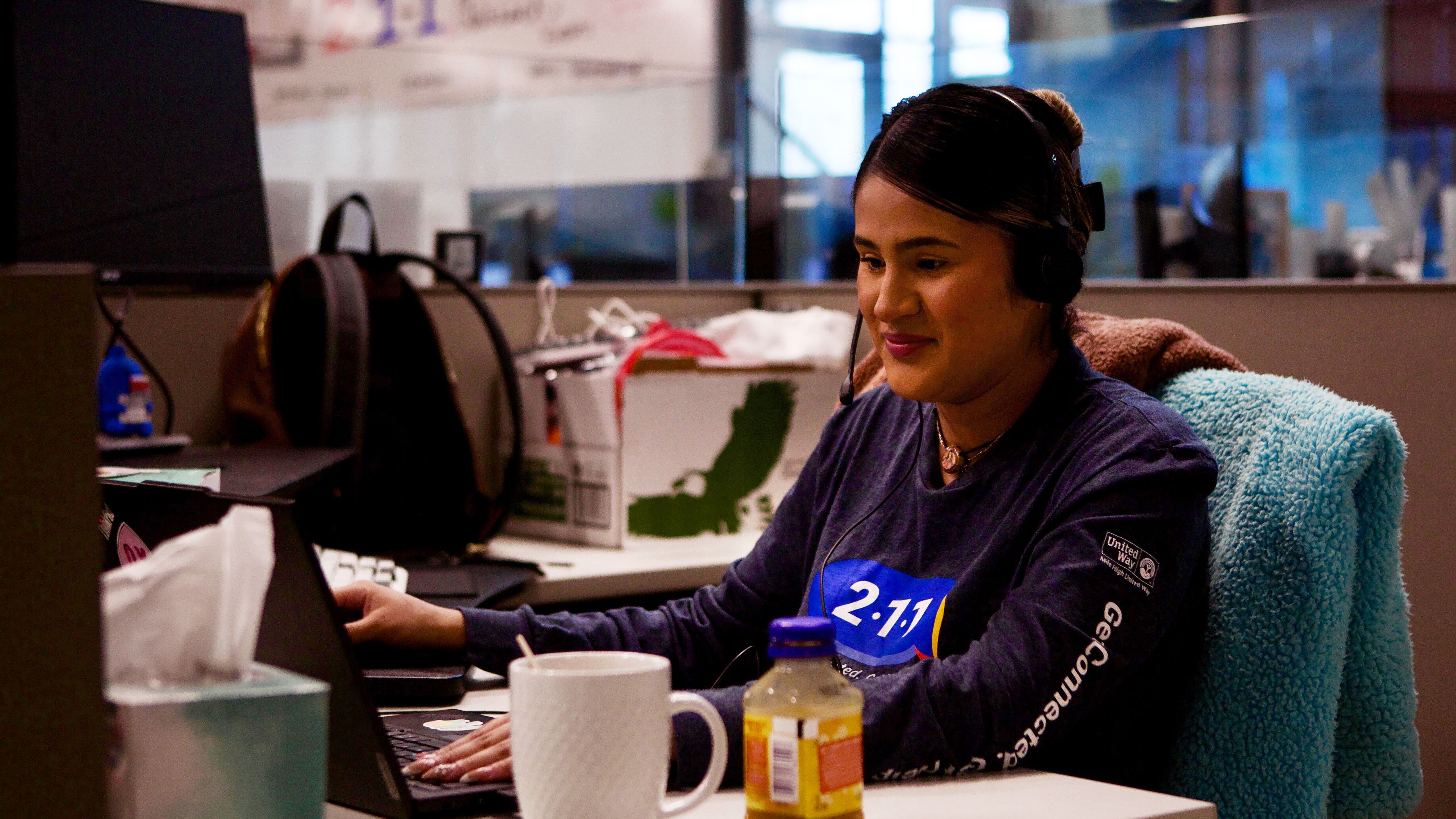 A Mile High United Way 211 navigator works at her desk, connecting callers to critical resources.