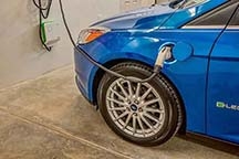 In the garage, a Schneider Electric EVlink electric vehicle charging station fuels the electric car.