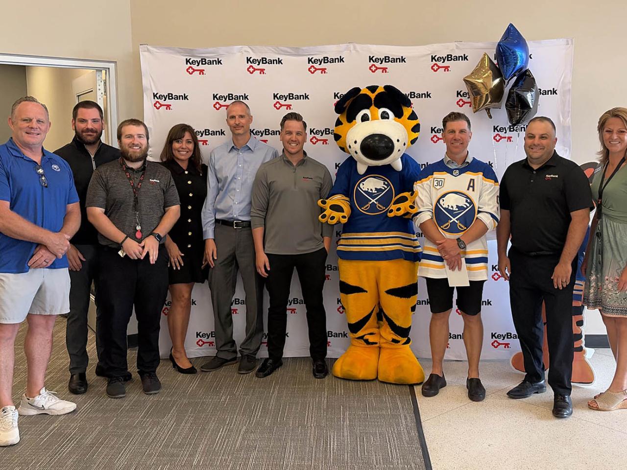 People standing together with Sabres mascot
