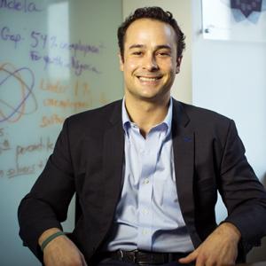 Man in dress shirt and blazer smiling