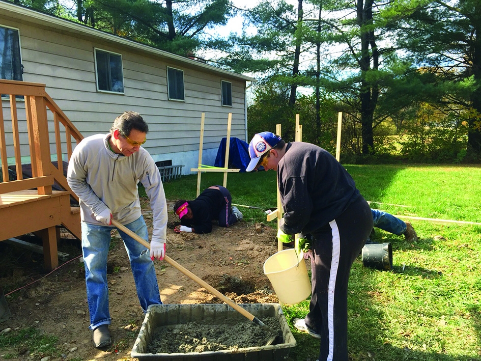 Through Habitat for Humanity’s home preservation program, Sanofi Pasteur employees mix cement and pour footers for a wheelchair ramp for a local disabled child. Habitat for Humanity’s home preservation program allows homeowners affected by low income, age or disability to make necessary repairs and renovations to their homes.